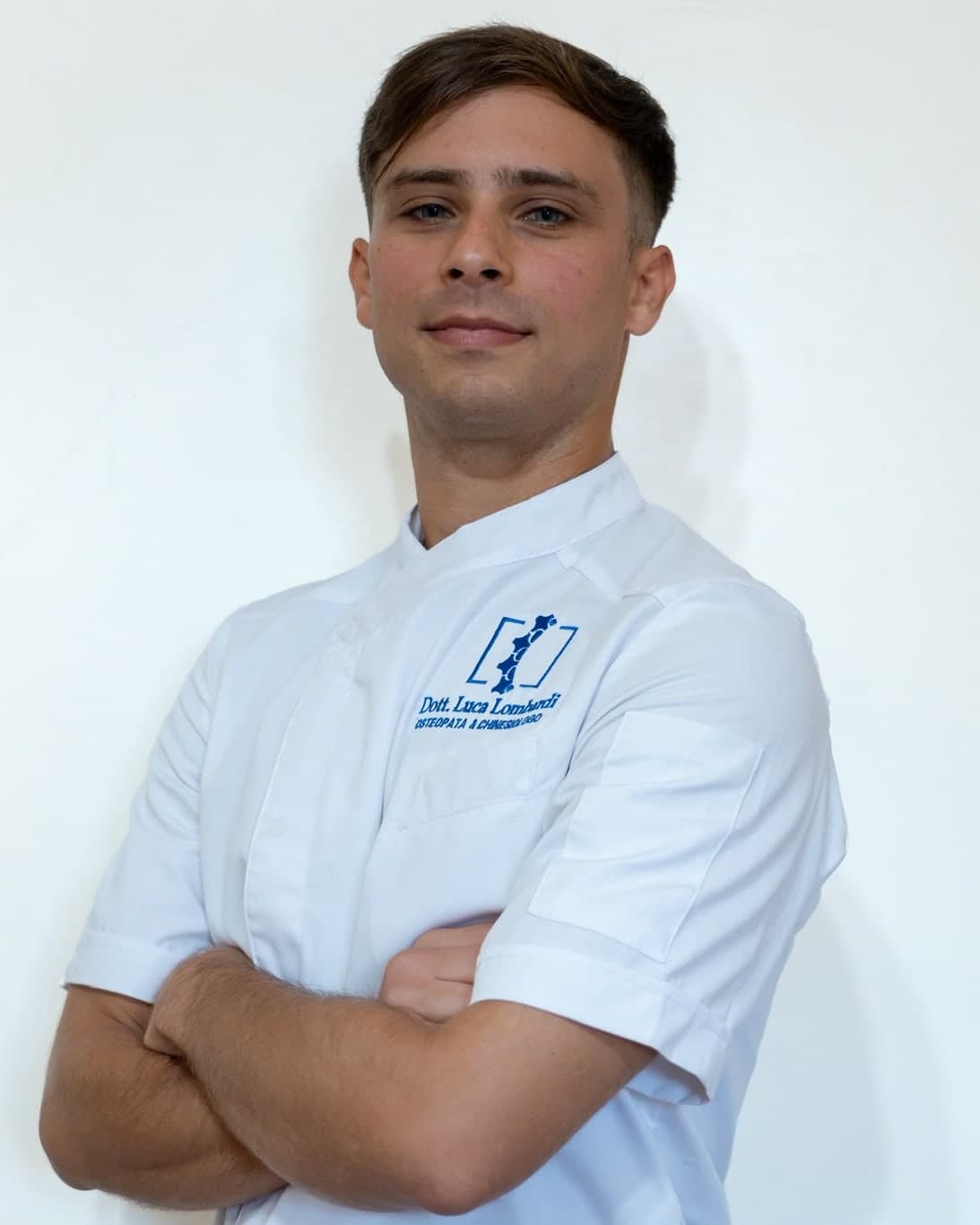 Luca Lombardi, osteopata e chinesiologo, in divisa bianca con le braccia conserte